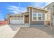 Charming gray home features a stone accent, two-car garage, and a welcoming front entrance at 9283 Biscay St, Commerce City, CO 80022