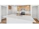 Modern kitchen featuring stainless steel appliances, a center island, and natural wood cabinetry at 9283 Biscay St, Commerce City, CO 80022