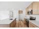 Well-lit kitchen features wood floors, stainless steel appliances, and ample cabinet space at 9283 Biscay St, Commerce City, CO 80022