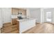 Open kitchen with an island, stainless steel appliances, and light hardwood floors at 9283 Biscay St, Commerce City, CO 80022