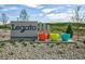 Community entrance sign that says 'Legato' and decorative colorful planters at 9283 Biscay St, Commerce City, CO 80022