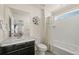 Bathroom showcasing vanity with marble countertop, decorative mirror, and adjacent bathtub-shower at 840 Avena Dr, Elizabeth, CO 80107