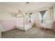 Bedroom with cozy decor, featuring a canopy bed, a rocking chair, and bright natural light at 840 Avena Dr, Elizabeth, CO 80107