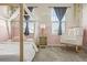 Bedroom with cozy decor, featuring a canopy bed, a rocking chair, and bright natural light at 840 Avena Dr, Elizabeth, CO 80107
