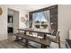 Dining area featuring a large wood table, decorative brick wall accent, bench seating, and stylish accents at 840 Avena Dr, Elizabeth, CO 80107