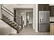 Inviting entryway with hardwood floors, a staircase, and stainless steel refrigerator at 840 Avena Dr, Elizabeth, CO 80107