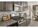Modern kitchen includes a stainless steel range, microwave, subway tile backsplash and granite countertops at 840 Avena Dr, Elizabeth, CO 80107