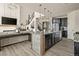 Open concept kitchen with stone accent island, stainless appliances, and seamless flow to the living area at 840 Avena Dr, Elizabeth, CO 80107