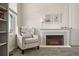 Cozy corner with a comfortable armchair, decorative fireplace, bookshelf, and sunlit window at 840 Avena Dr, Elizabeth, CO 80107