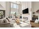Bright living room features large windows, fireplace, modern chandelier, and neutral decor at 840 Avena Dr, Elizabeth, CO 80107