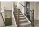 Carpeted staircase with decorative wood and iron railing and green accent wall at 840 Avena Dr, Elizabeth, CO 80107