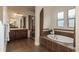 Luxurious bathroom featuring a soaking tub, a glass-enclosed shower, and a double vanity at 9266 E 35Th Ave, Denver, CO 80238