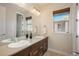 Bright bathroom featuring double sinks with a large mirror, a window with a blind, and modern fixtures at 9266 E 35Th Ave, Denver, CO 80238