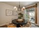 Cozy dining area with a round table, stylish chandelier, and sliding glass doors to the outdoor patio at 9266 E 35Th Ave, Denver, CO 80238