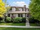 Charming two-story home features a stone chimney, manicured lawn, and lush landscaping at 9266 E 35Th Ave, Denver, CO 80238