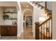 Inviting hallway with hardwood floors, elegant archways, and a staircase with iron railings at 9266 E 35Th Ave, Denver, CO 80238