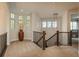 Bright upstairs landing with large windows, elegant railing, and neutral carpeting at 9266 E 35Th Ave, Denver, CO 80238