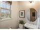 Stylish powder room with a round mirror, modern vanity, and a decorative window at 9266 E 35Th Ave, Denver, CO 80238