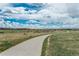 Scenic view of walking path near houses under a dramatic sky with puffy white clouds at 9266 E 35Th Ave, Denver, CO 80238