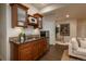 Wet bar with wooden cabinets, granite countertops, microwave and stainless-steel refrigerator at 9266 E 35Th Ave, Denver, CO 80238