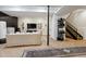 Basement lounge area with comfortable seating, stylish staircase, and herringbone flooring at 1140 Lake Gulch Rd, Castle Rock, CO 80104