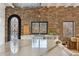 Stunning kitchen featuring a large marble island and a stainless steel sink overlooking trees and nature at 1140 Lake Gulch Rd, Castle Rock, CO 80104