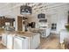 Open kitchen with large island, white cabinets, modern appliances, brick wall, and modern lighting at 1140 Lake Gulch Rd, Castle Rock, CO 80104