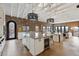 Open kitchen with large island, breakfast bar, brick wall, modern appliances, and wood beam ceiling at 1140 Lake Gulch Rd, Castle Rock, CO 80104