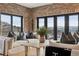 Inviting living room with brick accent wall, modern furniture, and scenic views from expansive windows and walk out deck at 1140 Lake Gulch Rd, Castle Rock, CO 80104