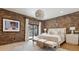 Bright bedroom with brick accent wall, sliding door, and modern furnishings at 1140 Lake Gulch Rd, Castle Rock, CO 80104