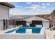 Inviting plunge pool with mountain view and modern design with black iron fence on spacious tiled patio at 1140 Lake Gulch Rd, Castle Rock, CO 80104