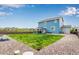 Large backyard featuring a green lawn, a covered patio, and gravel landscaping at 10 N Quantock St, Aurora, CO 80018