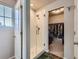 Modern bathroom with a glass shower, white tile, and a walk-in closet space at 10 N Quantock St, Aurora, CO 80018