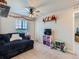 Bright bedroom featuring a plush couch, a ceiling fan, and shelving, creating a fun and cozy atmosphere at 10 N Quantock St, Aurora, CO 80018