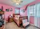 Pink-themed bedroom with a wooden bed, side table, and natural light from the window at 10 N Quantock St, Aurora, CO 80018