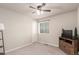 Cozy bedroom features a ceiling fan, neutral carpet, a window, and a TV on a wooden stand at 10 N Quantock St, Aurora, CO 80018