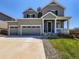 Inviting two-story home featuring a three-car garage, manicured lawn, and charming covered porch at 10 N Quantock St, Aurora, CO 80018