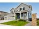 Charming two-story home featuring a welcoming front porch and manicured lawn at 10 N Quantock St, Aurora, CO 80018