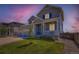 Charming two-story home with a well-manicured lawn and inviting front porch, showcasing its curb appeal at twilight at 10 N Quantock St, Aurora, CO 80018