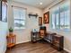 Bright home office featuring wood floors, natural light from two windows, and modern furnishings at 10 N Quantock St, Aurora, CO 80018