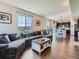 Spacious living room showcasing an open floor plan, hardwood floors, and large windows offering ample natural light at 10 N Quantock St, Aurora, CO 80018