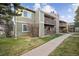 This exterior view shows two-story condos with wooden decks, patios, and well-maintained landscaping at 3400 S Eagle St # 104, Aurora, CO 80014