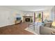 The comfortable living room features a stone fireplace, wood floors, and access to the outdoor balcony at 3400 S Eagle St # 104, Aurora, CO 80014