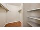 Spacious walk-in closet with built-in shelving and wood floors at 3400 S Eagle St # 104, Aurora, CO 80014