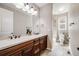 Bathroom featuring a large double vanity with two sinks, a large mirror, and tile flooring at 13912 Ashgrove Cir, Parker, CO 80134