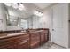 Modern bathroom with double sinks and large mirror, plus a partial view of the shower at 13912 Ashgrove Cir, Parker, CO 80134
