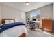 Bright bedroom with carpet flooring, a desk, a bed, and a window with natural light at 13912 Ashgrove Cir, Parker, CO 80134