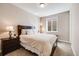 Cozy bedroom with neutral walls, carpet flooring, a queen bed, side tables, and a sunny window at 13912 Ashgrove Cir, Parker, CO 80134