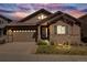 Sunset view of a beautiful single-Gathering home featuring a two-car garage and a stone-accented facade at 13912 Ashgrove Cir, Parker, CO 80134