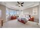 Primary bedroom boasts tray ceilings, large bay windows, ceiling fan, and carpet flooring at 13912 Ashgrove Cir, Parker, CO 80134
